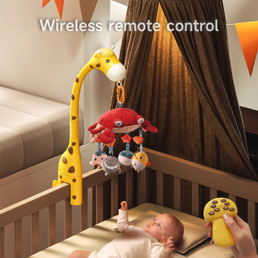 Baby lying in crib looking at hanging plush sea animal mobile attached to a giraffe-shaped arm, with an adult hand holding a yellow wireless remote control to operate the toy.