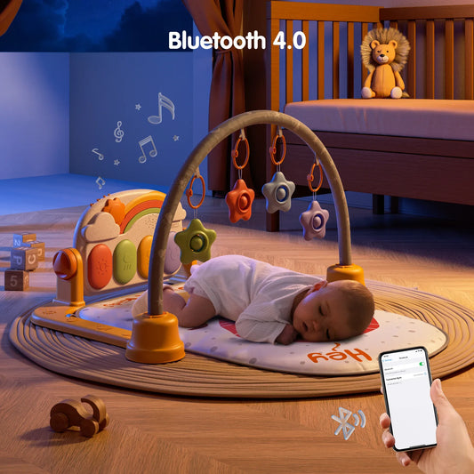 Baby sleeping on a lion-themed baby jungle gym with star-shaped hanging rattles, rainbow musical piano keyboard, and Bluetooth 4.0 wireless control shown on a smartphone.