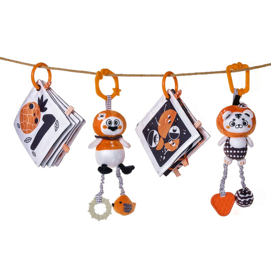 High-contrast baby toy set with orange, black, and white colors, featuring two soft fabric books and two plush animal toys hanging from an overhead rope with orange hooks. The books display bold, simple illustrations and numbers for visual stimulation, while the plush toys include teething elements and dangling accessories for sensory and motor skill development.