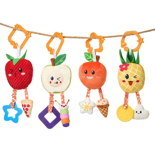 A colorful set of four hanging baby toys shaped like smiling fruits—strawberry, apple, orange, and pineapple—each with soft textures, expressive embroidered faces, and dangling accessories like teethers, plush food shapes, and a caterpillar. The toys are attached to a rope using orange plastic star-patterned hooks.