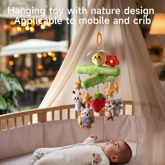 A baby lying in a crib looks up at a Woodland Animal Crib Mobile, which features a green tree branch design with a yellow bee and red flower at the top. Plush toys including stars, a ladybug, an owl, a strawberry, a sloth, and a raccoon hang from the mobile. Applicable to mobile and crib.