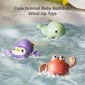Three colorful wind-up bath toys float and move in water: a purple penguin, a green whale, and a red crab, each with playful cartoon expressions. Splashes of water surround them, showing their movement. The text “Cute Animal Baby Bathtub Wind Up Toys” appears at the top, highlighting their fun interactive design for bath time.