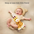 A smiling baby lying on a bed with a bear-shaped pillow, holding a cute giraffe baby security blanket. The text above says, 
