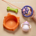 Top view of toy dog accessories made from safe materials, including an orange cat-shaped food bowl labeled 'TK Tumama', a green bone, a purple and pink paw-shaped leash handle held by a child's hand, and a white and pink sippy cup, all placed on a beige background. Caption reads: 'Safe material'.