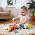 Smiling baby playing with a colorful stuffed caterpillar toy featuring a pull-out bee, promoting tactile stimulation and sensory development; designed with multiple textures and patterns for interactive learning.
