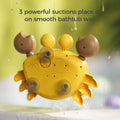 The back view of a yellow crab-shaped bubble bath toy shows three strong suction cups attached to a smooth bathtub wall, ensuring firm placement. Water droplets are visible on the surface, and the text “3 powerful suctions place it on smooth bathtub wall” appears at the top, emphasizing its secure design.