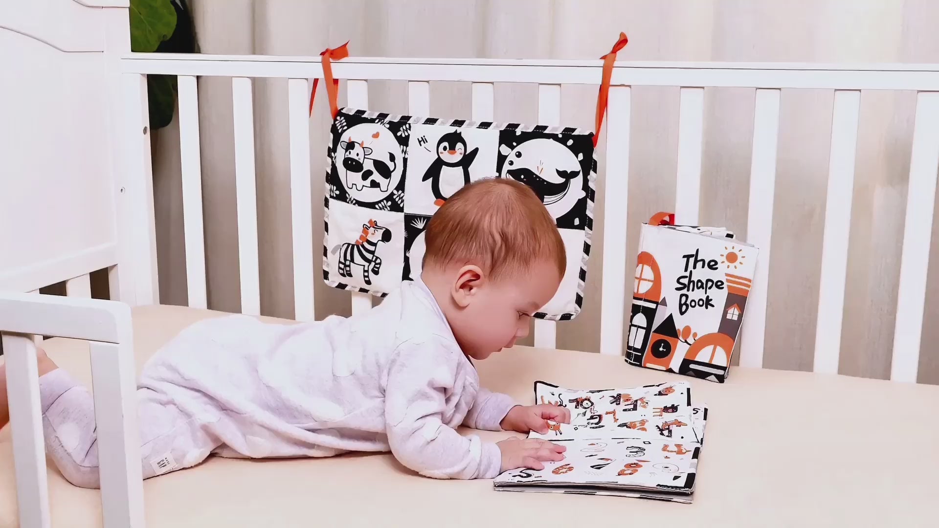 baby-plays-with-black-and-white-soft-books-in-crib