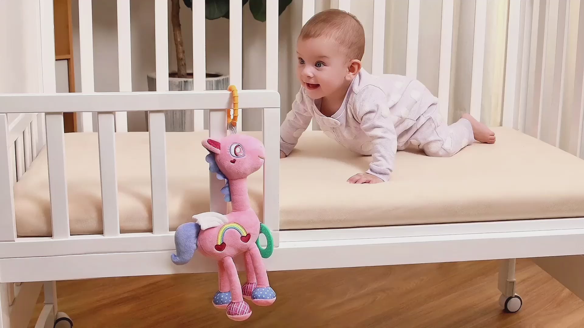 Baby-chews-and-plays-with-this-pink-horse-plush-hanging-rattle